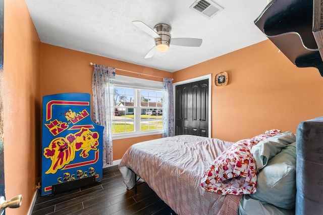 bedroom featuring visible vents, wood finished floors, a closet, baseboards, and ceiling fan