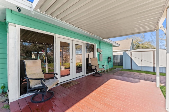 deck with french doors, a storage unit, an outdoor structure, and fence