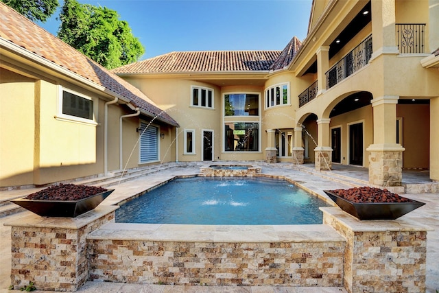 outdoor pool with a patio area and an in ground hot tub