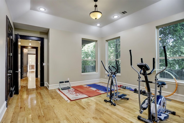 exercise room with recessed lighting, visible vents, light wood-style flooring, and baseboards