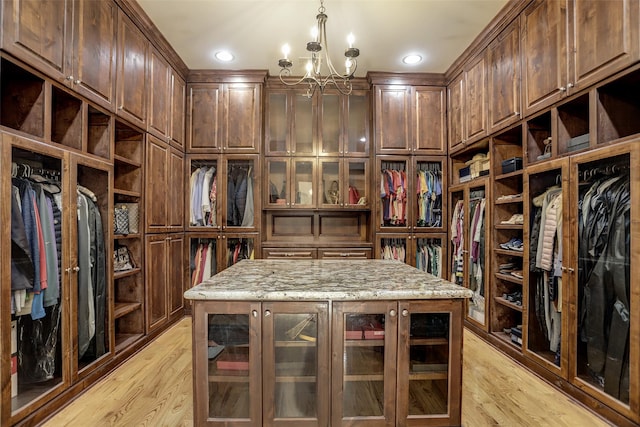 spacious closet featuring light wood-style floors and a chandelier