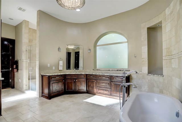 bathroom with visible vents, a washtub, a shower stall, a chandelier, and vanity