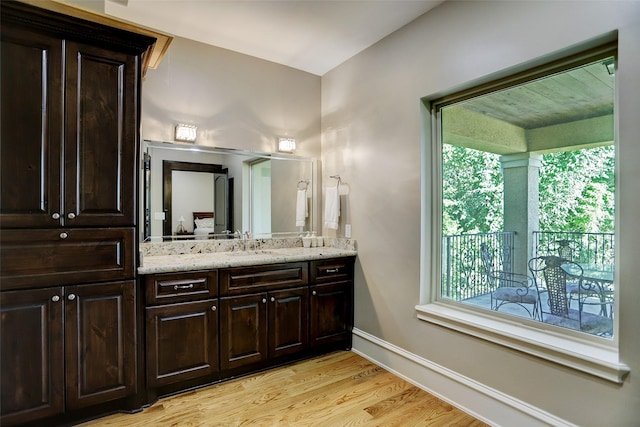 bathroom featuring vanity, baseboards, and wood finished floors