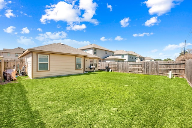 back of house featuring a lawn and a fenced backyard