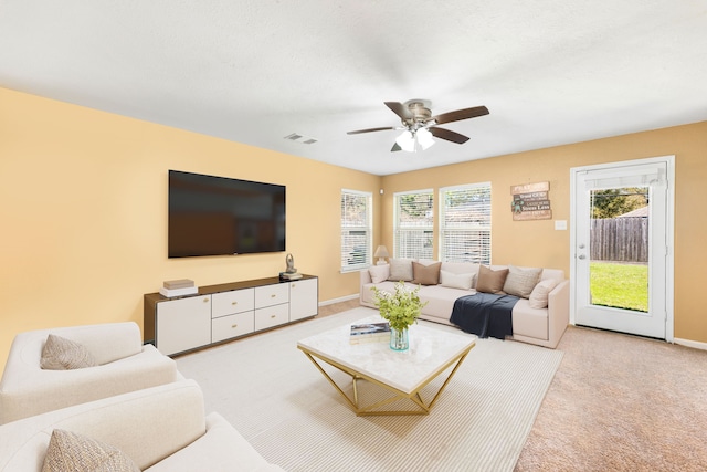 carpeted living room featuring visible vents, baseboards, and ceiling fan