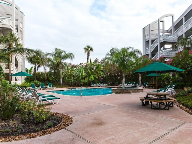 community pool featuring a community hot tub and a patio area