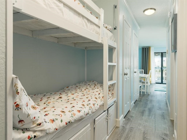 bedroom with light wood finished floors and a textured ceiling