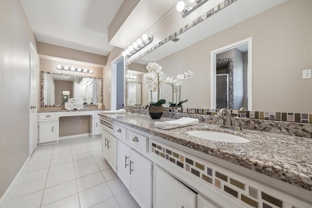 bathroom featuring tile patterned floors, a shower with door, double vanity, and a sink