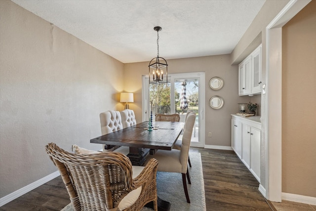 dining area with dark wood finished floors, a notable chandelier, and baseboards