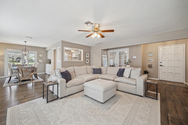 living area featuring baseboards, french doors, wood finished floors, a textured ceiling, and a ceiling fan