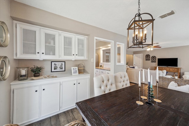 dining space with visible vents, dark wood finished floors, and a ceiling fan