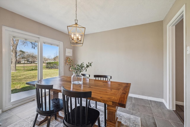 dining room featuring an inviting chandelier and baseboards