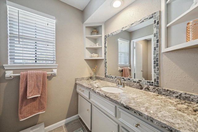 bathroom featuring tile patterned flooring, vanity, and baseboards