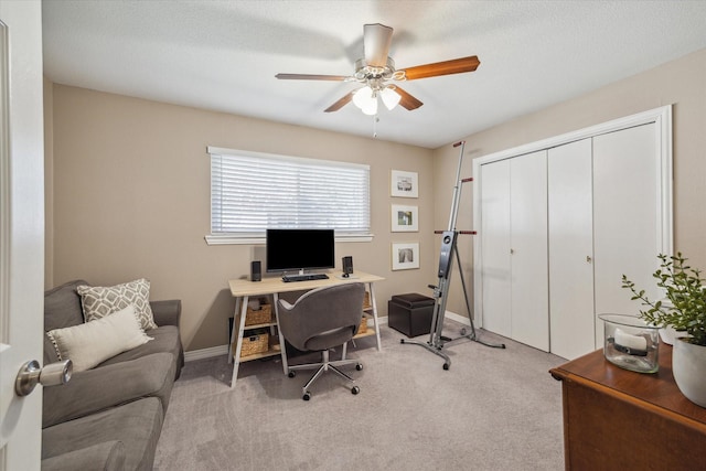 office area featuring baseboards, light colored carpet, and a ceiling fan