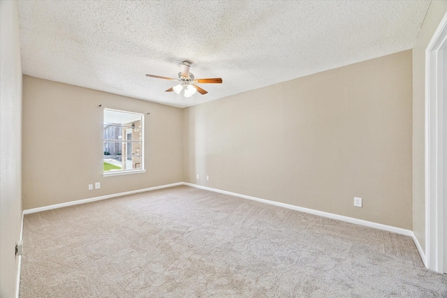 carpeted empty room featuring ceiling fan, a textured ceiling, and baseboards