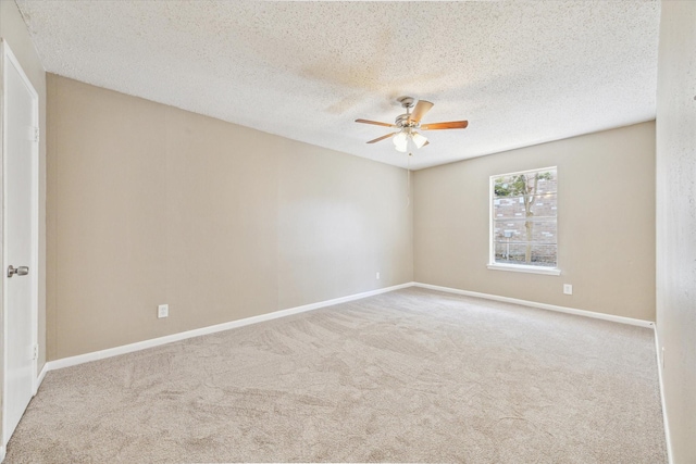 carpeted empty room featuring baseboards, a textured ceiling, and a ceiling fan