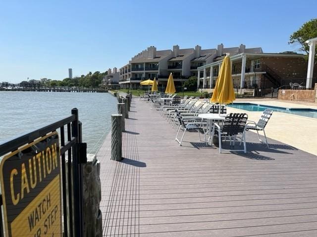 dock area featuring a water view and a community pool