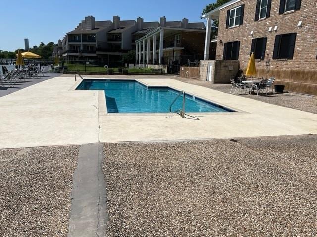 pool featuring fence and a patio area