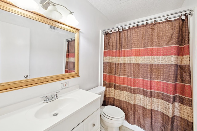 bathroom featuring visible vents, toilet, vanity, a shower with shower curtain, and a textured ceiling