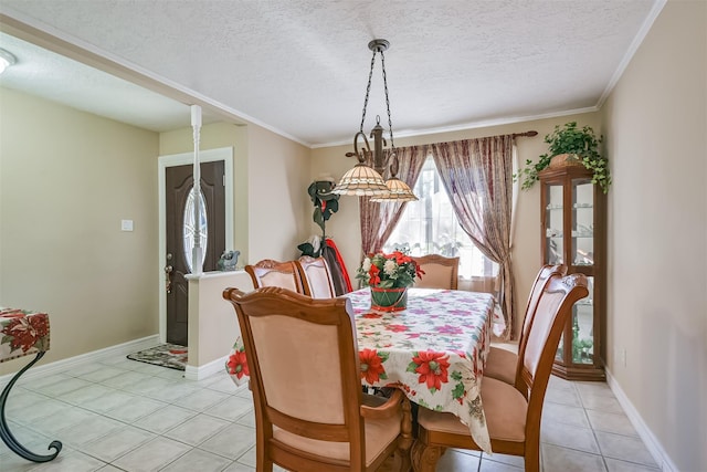 dining space featuring light tile patterned floors, baseboards, a textured ceiling, and ornamental molding