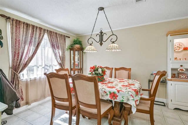 dining area with light tile patterned floors, a textured ceiling, baseboards, and ornamental molding