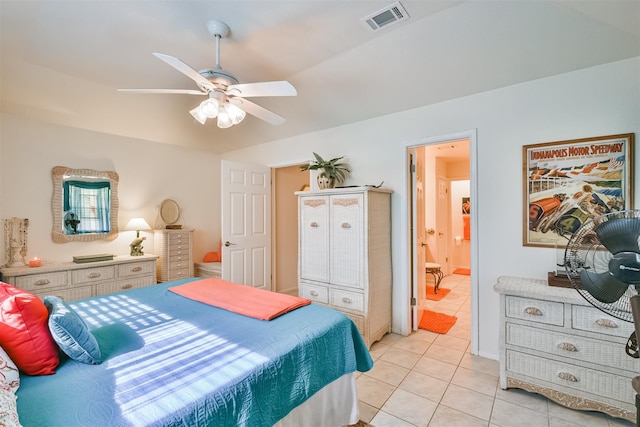 bedroom with ensuite bath, light tile patterned floors, a ceiling fan, and visible vents