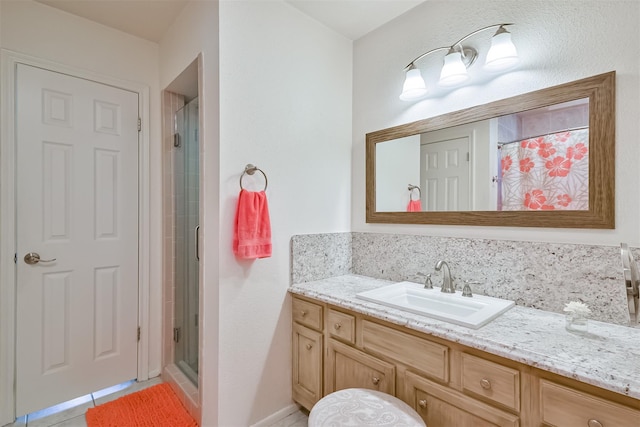 full bath with tile patterned floors, a shower stall, vanity, and tasteful backsplash