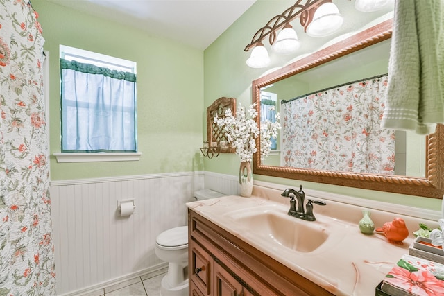 full bath with tile patterned floors, a wainscoted wall, toilet, curtained shower, and vanity