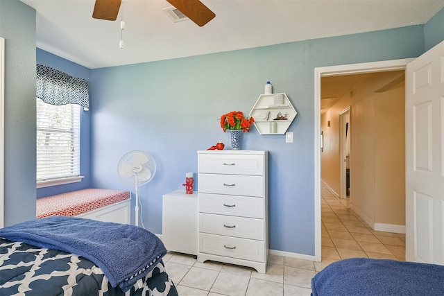 bedroom with light tile patterned flooring, visible vents, baseboards, and a ceiling fan