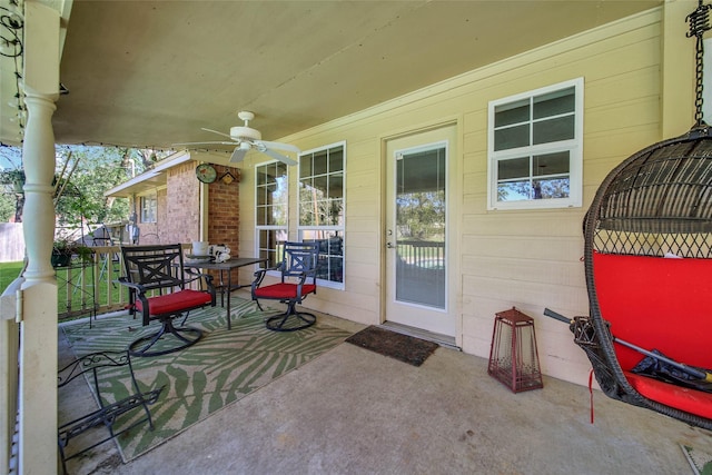 view of patio with outdoor dining area and a ceiling fan