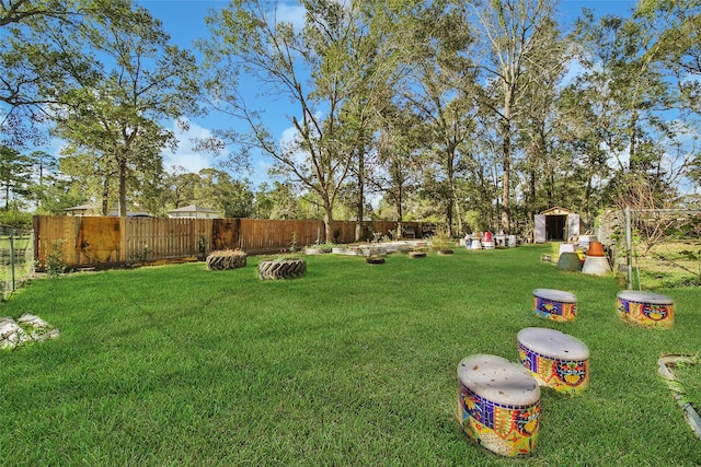 view of yard featuring a shed, an outdoor structure, and a fenced backyard