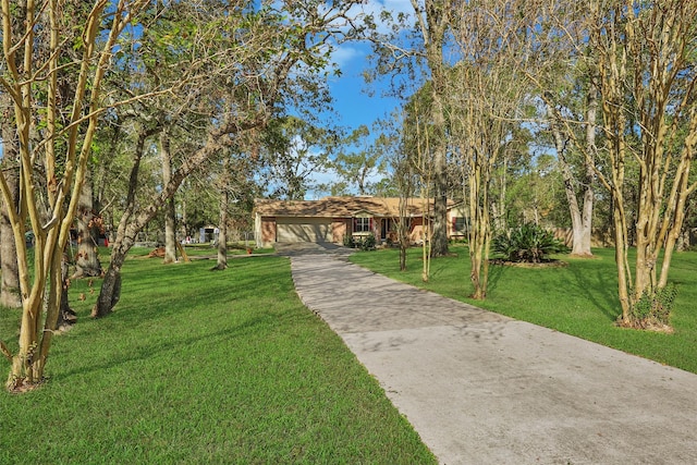 view of community with concrete driveway, an attached garage, and a yard