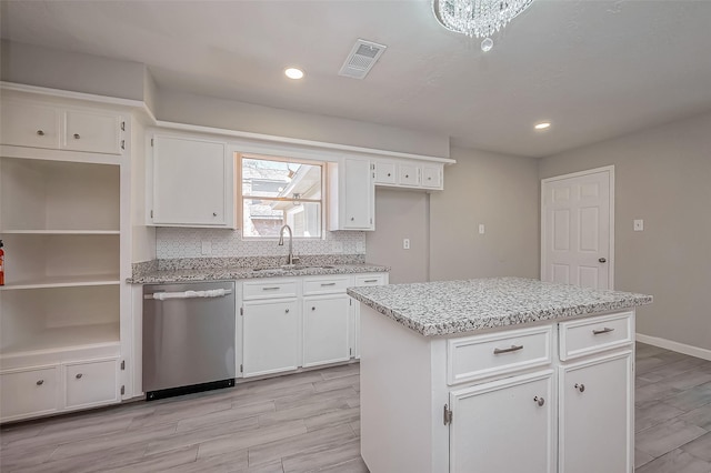 kitchen featuring visible vents, dishwasher, decorative backsplash, white cabinets, and a sink