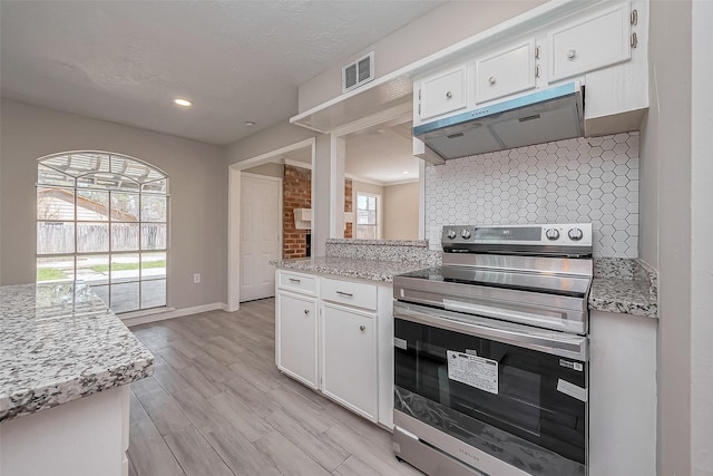 kitchen with visible vents, electric range, decorative backsplash, under cabinet range hood, and white cabinetry