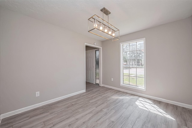 empty room with baseboards and wood finished floors