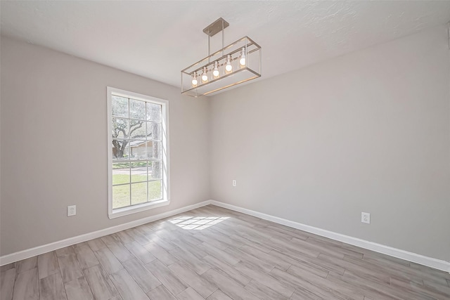 unfurnished room with baseboards and wood finished floors