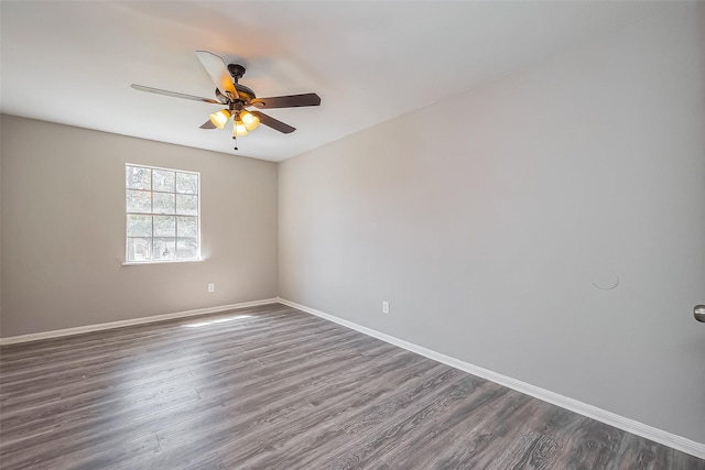 unfurnished room featuring a ceiling fan, baseboards, and dark wood-style flooring