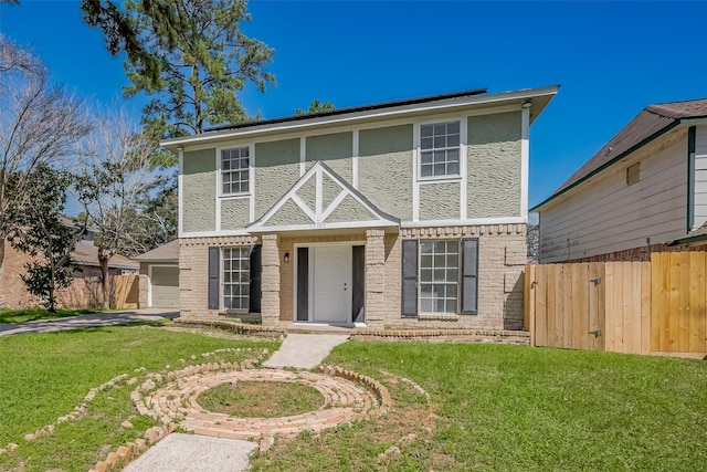 view of front of house featuring brick siding, a front lawn, fence, stucco siding, and a garage