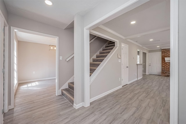 staircase with recessed lighting, wood finished floors, baseboards, and ornamental molding