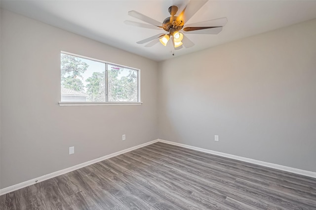 unfurnished room featuring ceiling fan, baseboards, and dark wood finished floors