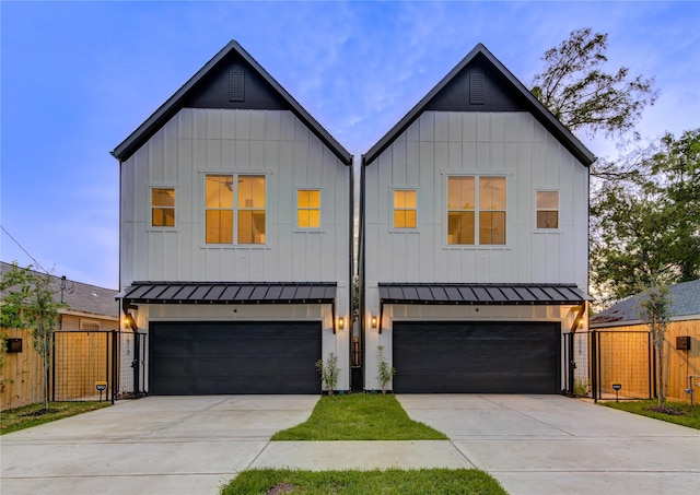 modern inspired farmhouse with a standing seam roof, concrete driveway, a gate, and an attached garage