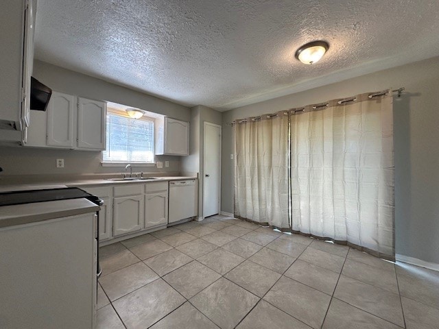 kitchen featuring light tile patterned flooring, a sink, light countertops, white cabinets, and dishwasher