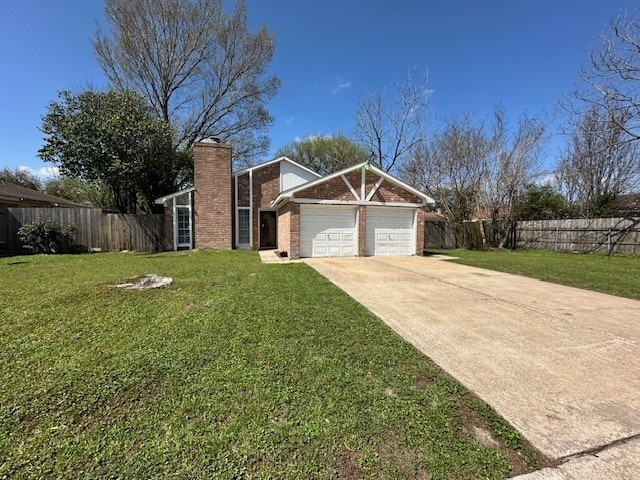 view of front of property featuring fence, concrete driveway, a front yard, a garage, and a chimney