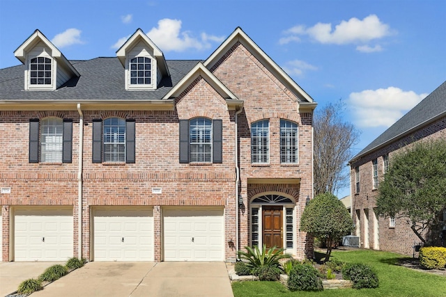 view of front of home with a garage, brick siding, driveway, and roof with shingles