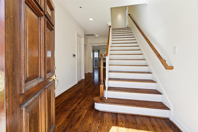 staircase with recessed lighting, wood finished floors, baseboards, and ornamental molding