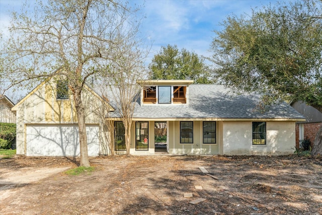 view of front of house featuring a garage, driveway, and roof with shingles