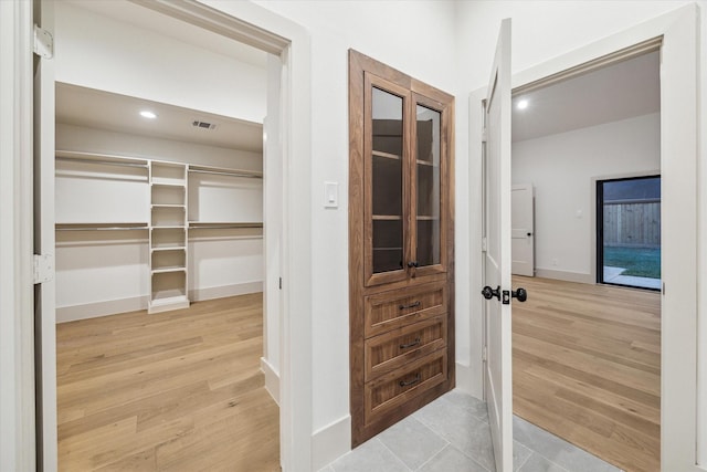 corridor featuring light wood-style flooring, recessed lighting, and baseboards