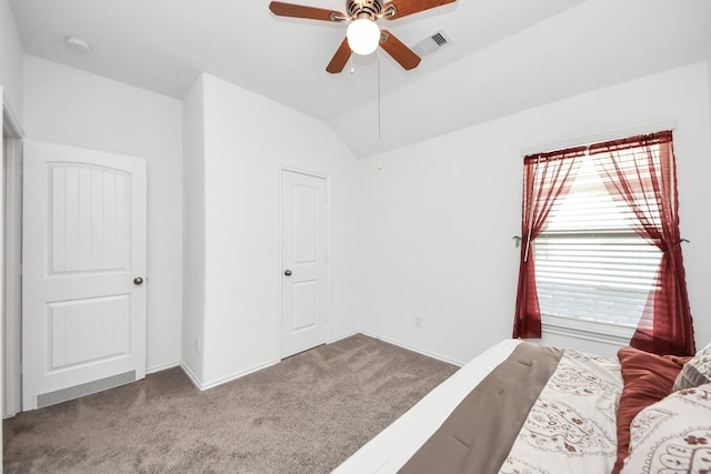 carpeted bedroom with visible vents, lofted ceiling, and ceiling fan