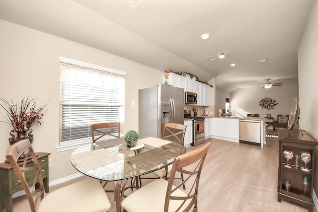 dining room with a ceiling fan, baseboards, recessed lighting, vaulted ceiling, and light wood-type flooring