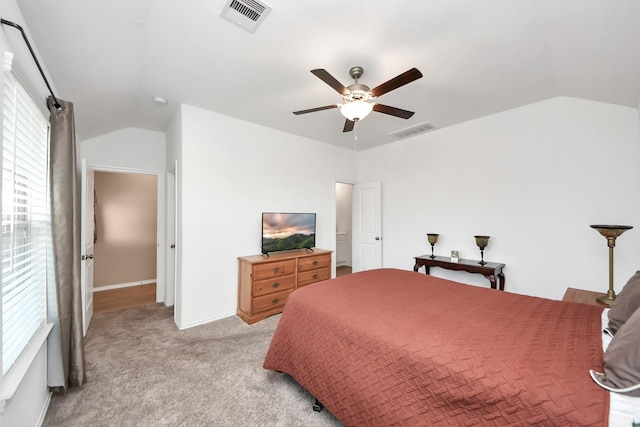 bedroom with visible vents, ceiling fan, carpet flooring, and vaulted ceiling